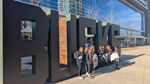 Girls basketball in front of Bucks sign